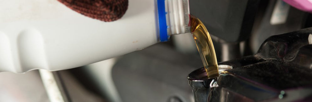 oil being poured into a dirt bike engine