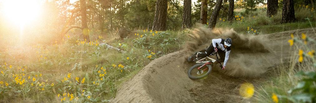 mountain biker railing a berm down hill