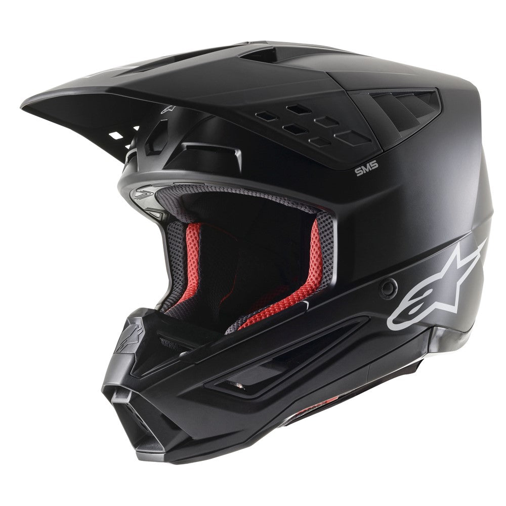 The Alpinestars S-M5 Solid Helmet in Matte Black, offered by Crown Kiwi Enterprises Limited, is a full-face MX helmet made from lightweight thermoplastic. It showcases an angular design with a large visor and red interior padding. The helmet is adorned with a white star logo on the side and includes top ventilation openings for enhanced comfort and impact protection.