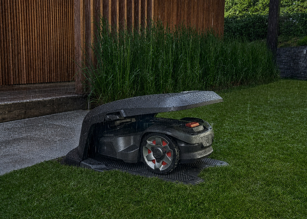Husqvarna Robotic Mower parked up out of the rain in its Automower House.