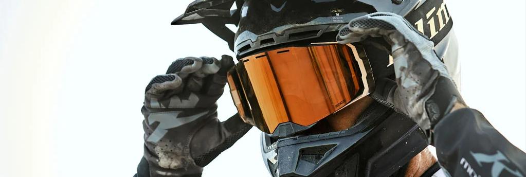 Motocross rider wearing orange lens goggles with black mx gear