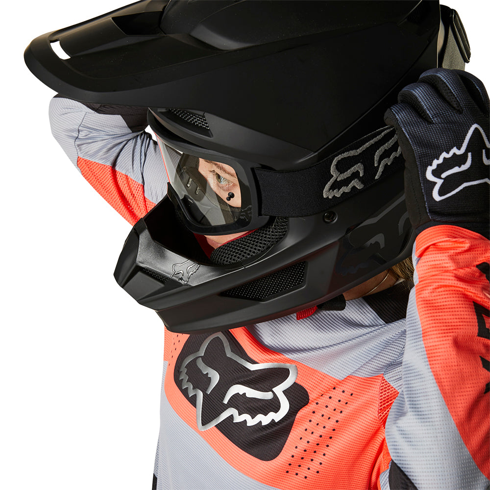 Motocross Kid wearing a black fox helmet and goggles with black fox gloves and orange and white fox mx jersey