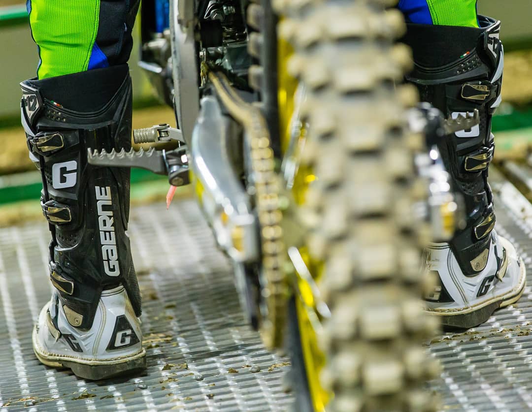 Rear tyre and person wearing gaerne boots at the start gate ready to race motocross