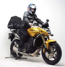 The Ventura EVO-12 Bike-Pack Kit for the Honda CB 600 Hornet (07-10) includes a black bike-pack with a zipper, an Adjustable Pack-Rack, and an L-bracket with screws. The pack and rack are labeled 'EVO-12 pack' and 'Adjustable Pack-Rack,' while the L-bracket is shown as a 'Generic Image.'.