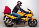 Image displays Ventura EVO-12 Bike-Pack, Evo-Rack on a Triumph Sprint RS 955i Y, K, 02, 03 (00-03) motorcycle, and L-bracket with screws. Each component is labeled underneath. Caption: "EVO-12 Bike-Pack Kit with Evo-Rack.