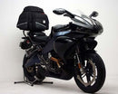 Image displaying a Ventura Buell 1125R (08-09) Bike-Pack Kit featuring a black EVO-12 pack with an orange accent, an Evo-Rack expertly mounted on the bike, and an L-bracket with screws, all presented as a generic image for versatility.