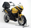 Three labeled items: Ventura EVO-12 bike-pack (black zippered bag), Adjustable Pack-Rack (black rear bike rack), and L-bracket with screws for Triumph Tiger 1050 (07-12). Text: "EVO-12 Bike-Pack Kit.