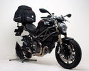 The Ventura EVO-12 Bike-Pack Kit for Ducati 1100 Monster EVO (11-12) includes a black EVO-12 pack, a black Adjustable Pack-Rack (EVO-Rack) mounted on the motorcycle, and an image of L-brackets with screws. Each item is clearly labeled.