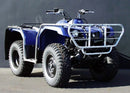 The Ventura Yamaha YFM 350FA Grizzly 4x4 Auto (12-17) ATV features a blue frame with large off-road tires, a tow ball, and metal racks on both ends. It sits on a concrete surface against a black wall and includes a black seat with mud flaps for utility and style.