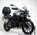 The Ventura Bike-Pack Kit for Triumph Tiger Explorer 1200 (12-18) includes three labeled parts: a black EVO-12 Pack, a black metal Adjustable Pack-Rack mounted on the bike, and a generic L-Bracket with hardware.
