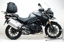 The Ventura Bike-Pack Kit for Triumph Tiger Explorer 1200 (12-18) includes three labeled parts: a black EVO-12 Pack, a black metal Adjustable Pack-Rack mounted on the bike, and a generic L-Bracket with hardware.