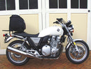 The image features the Ventura EVO-12 Bike-Pack Kit for Honda CB 1100 (10-15), including a black EVO-12 Pack with logo, a metal Top-Box Rack fitted on the bike, and an L-bracket with screws.