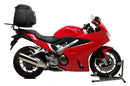 The Honda VFR 800FE (14-18) Bike-Pack Kit by Ventura is showcased with an Evo-Rack attached to a motorcycle, featuring the EVO-12 pack, a generic L-bracket, screws, and accessories, highlighting its versatility as an Adjustable Pack-Rack solution.