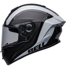 Side view of the Bell RACE STAR DLX FLEX Tantrum 2 Black/White helmet with a clear visor. The helmet boasts a sleek design with aerodynamic contours, Velocity Flow Ventilation, and a textured pattern on the top and sides. A Carbon Fiber Shell ensures durability, while the BELL logo is prominently displayed.