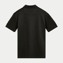 A person wearing the Realm Polo Shirt Black by Crown Kiwi Enterprises Limited stands against a white background. This polo features an embroidered logo on the chest, short sleeves, and a buttoned collar, crafted from jacquard mesh for enhanced breathability.