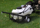The BE Pressure - Sprayer + Trailer 15gal, produced by BE Pressure Supply Ltd., is a white lawn sprayer contained in a 15-gallon tank mounted on a black frame with wheels. Hitched to a small vehicle on the grassy lawn, this setup includes hoses for efficient spraying and is ready for use.