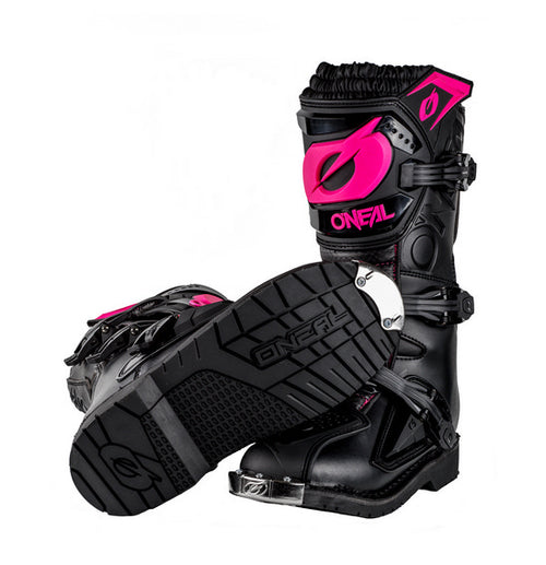 The O'Neal Women's RIDER PRO Boot in Black/Pink features the brand name "ONEAL" prominently and boasts multiple buckles along with rugged soles that have "ONEAL" embossed on the bottom. One boot stands upright while the other is tilted to display the sole, making them perfect for any motocross enthusiast.