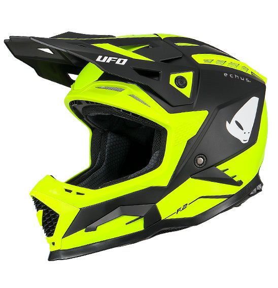 The UFO Echus Helmet in neon yellow and black features angular geometric designs, an alien logo near the back, and "UFO" branding. ECE 22.06 certified, it ensures top-notch safety for off-road adventures with its visor-equipped design.