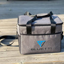 The BLUETTI Carry Bag for EB70/EB55/AC60/AC70 is a gray portable cooler bag with black trim and the "BLUETTI" logo prominently displayed on the front. It is crafted to complement your EB70 and includes a top handle along with an adjustable shoulder strap. The design also incorporates mesh pockets on the sides for additional storage.