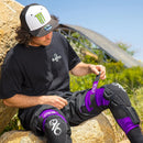 The EVS Sports SLAYCO96 Knee Guard | Purple features black and purple padded CE Level 2 knee and shin protection with white graphics and logos, shown upright side by side for top motocross safety.