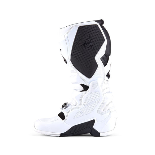 The ALPINESTARS Tech-7 MX Boots in white/black offer adjustable straps and protective features, designed for motocross or off-road use. They feature a sleek, sturdy design, impact resistance, and prominent branding on the top section.