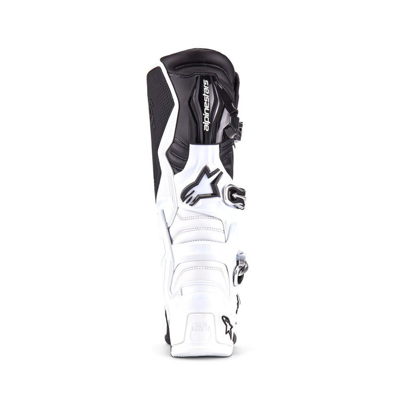 The ALPINESTARS Tech-7 MX Boots in white/black offer adjustable straps and protective features, designed for motocross or off-road use. They feature a sleek, sturdy design, impact resistance, and prominent branding on the top section.