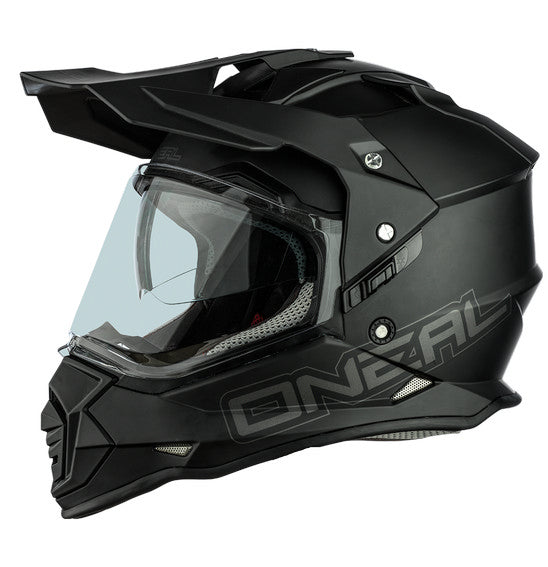 The O'Neal SIERRA Helmet R V.23 in flat black features a matte finish and angular, geometric design details on top; "ONEAL" branding is near the visor front, making it ideal for adventure bike riders.