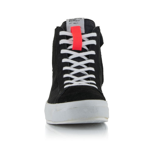 The Stella Stated Podium Shoes by Crown Kiwi Enterprises Limited are black high-top skate shoes designed with abrasion-resistant materials, featuring white soles and laces. The tongue includes a red pull tab for easy access. For a stylish display, the left shoe is positioned at an angle, slightly in front of the right.