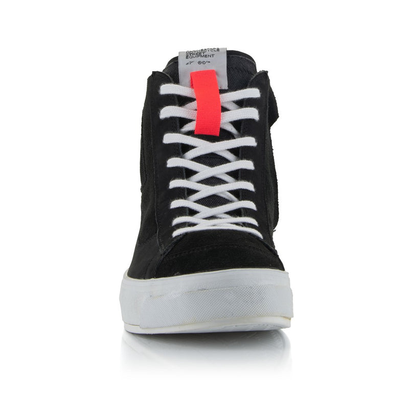 The Stella Stated Podium Shoes by Crown Kiwi Enterprises Limited are black high-top skate shoes designed with abrasion-resistant materials, featuring white soles and laces. The tongue includes a red pull tab for easy access. For a stylish display, the left shoe is positioned at an angle, slightly in front of the right.