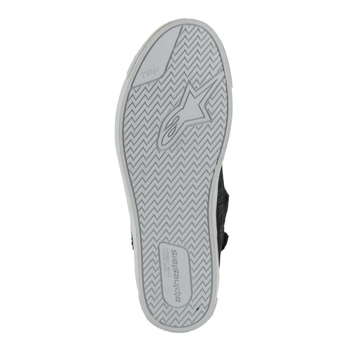 The Stella Stated Podium Shoes by Crown Kiwi Enterprises Limited are black high-top skate shoes designed with abrasion-resistant materials, featuring white soles and laces. The tongue includes a red pull tab for easy access. For a stylish display, the left shoe is positioned at an angle, slightly in front of the right.