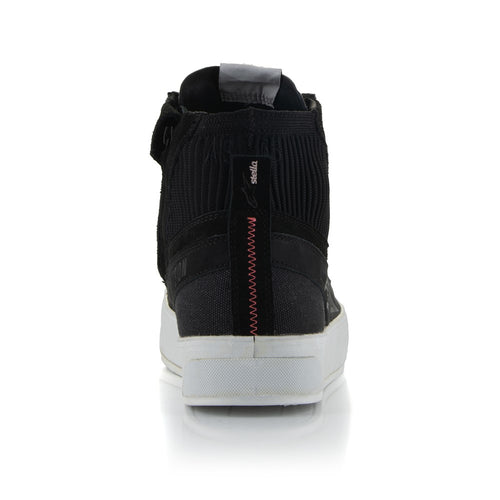 The Stella Stated Podium Shoes by Crown Kiwi Enterprises Limited are black high-top skate shoes designed with abrasion-resistant materials, featuring white soles and laces. The tongue includes a red pull tab for easy access. For a stylish display, the left shoe is positioned at an angle, slightly in front of the right.