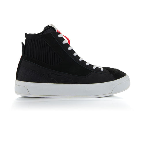 The Stella Stated Podium Shoes by Crown Kiwi Enterprises Limited are black high-top skate shoes designed with abrasion-resistant materials, featuring white soles and laces. The tongue includes a red pull tab for easy access. For a stylish display, the left shoe is positioned at an angle, slightly in front of the right.