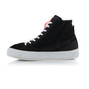 The Stella Stated Podium Shoes by Crown Kiwi Enterprises Limited are black high-top skate shoes designed with abrasion-resistant materials, featuring white soles and laces. The tongue includes a red pull tab for easy access. For a stylish display, the left shoe is positioned at an angle, slightly in front of the right.