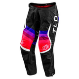 The Troy Lee Designs YOUTH GP PRO PANT REVERB BLACK / GLO RED features red, purple, and pink gradient thigh panels, durable 600D polyester, white accents, TLD lettering on the right leg, buckle closure, and reinforced knees for motos.