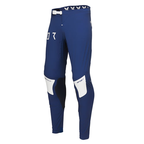 The THOR PANTS SPORT STRIKE NAVY, designed by THOR MX, feature a sleek navy design with white and black accents that ensure unrestricted mobility. The brand name "THOR" is prominently displayed on the right thigh in white letters. Crafted for athletic performance, these pants incorporate reinforced knee areas and a secure white buckle at the waist.