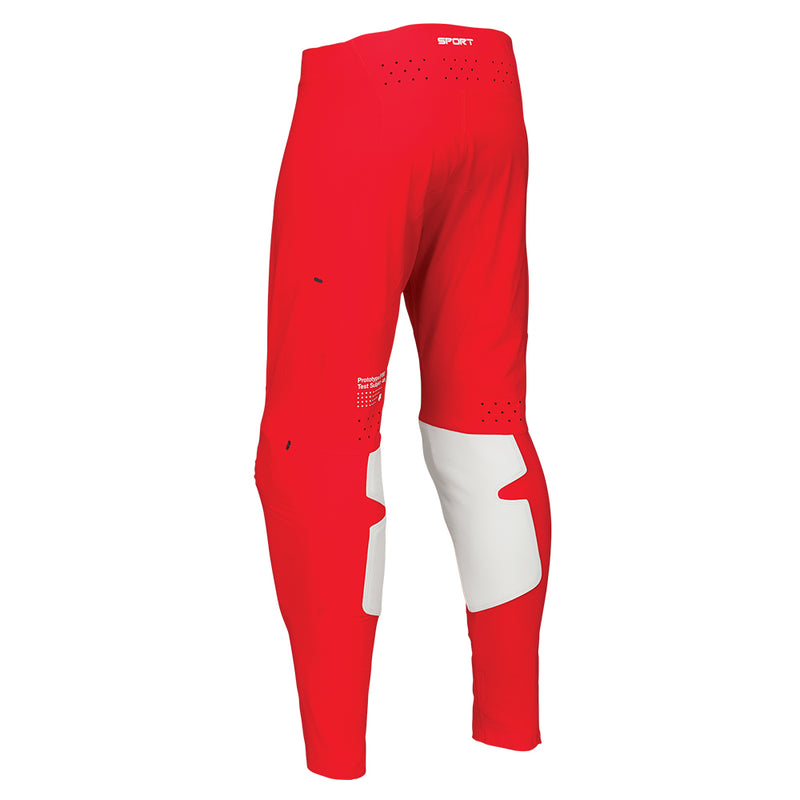 The THOR PANTS SPORT RIOT BLACK/RED by THOR MX offer a striking design with black, red, and white accents and a stylish logo. These pants are perfect for embodying motocross culture, featuring padded knee sections and a fitted waistband to ensure durability and comfort during off-road biking or racing activities.