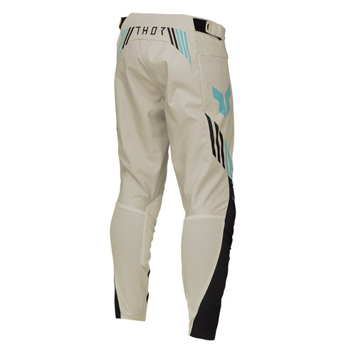 From the LAUNCHMODE collection, the THOR PANTS LAUNCH ZONE SAND by THOR MX are off-road motorcycle pants in beige with black and teal accents. They are crafted from poly stretch fabric for exceptional flexibility and include ventilation holes, a ratchet waist closure system, and reinforced knee areas to ensure both comfort and protection.