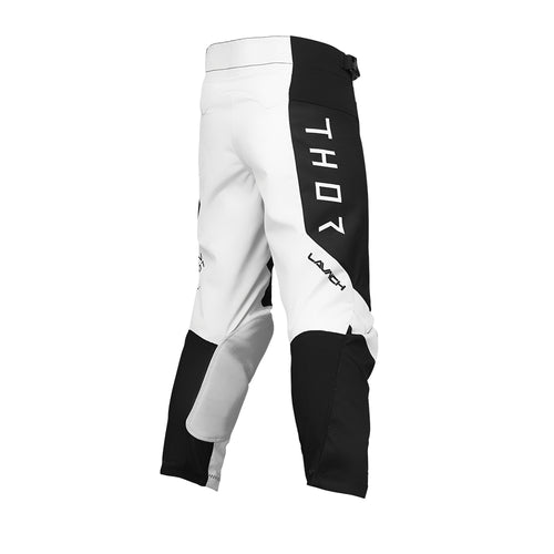 THOR MX presents the Launch Youth Storm Black pants, designed for motocross enthusiasts. These black and white pants feature "THOR" written vertically on the upper left thigh and are part of the esteemed Launch collection. They boast reinforced knee areas, durable full-grain leather accents, and a secure adjustable waistband, making them ideal for off-road biking and racing.