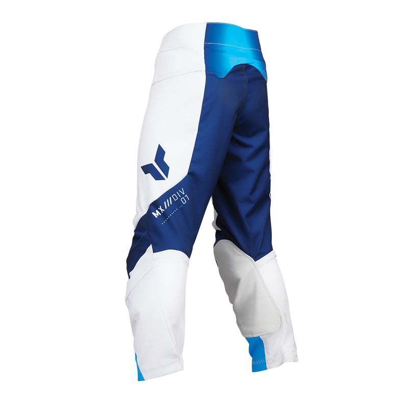 The THOR MX Launch Youth Storm White pants are crafted with durability in mind, showcasing a white fabric enhanced with blue and black accents. They feature padded knees for protection, a flexible and moisture-wicking design, and proudly display the brand name "Thor" printed vertically on the side.