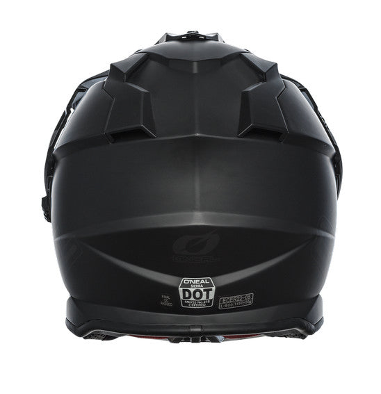 The O'Neal SIERRA Helmet R V.23 in flat black features a matte finish and angular, geometric design details on top; "ONEAL" branding is near the visor front, making it ideal for adventure bike riders.