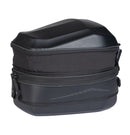 An open view of the OGIO TB1 TAIL BAG 14L - Ram Mount, a small black rectangular hardshell case, reveals an interior lined with soft padded material for protection. The exterior showcases its textured finish and two metal rivets on the front, with a zipper running along the edge.