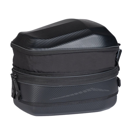 An open view of the OGIO TB1 TAIL BAG 14L - Ram Mount, a small black rectangular hardshell case, reveals an interior lined with soft padded material for protection. The exterior showcases its textured finish and two metal rivets on the front, with a zipper running along the edge.