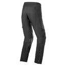 The Alpinestars AMT-8 Stretch Drystar XF Pants by ALPINESTARS are black, featuring articulated knees, multiple zippered pockets, a star-like logo on the right thigh, and an adjustable waist buckle. They're made from durable Drystar®XF fabric for adventure riding and outdoor activities.