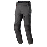 The Alpinestars Bogota Pro Drystar Pants feature an adjustable waist, knee pads, zippered pockets, and reinforced stitching for protection and comfort. These black adventure riding pants by ALPINESTARS are displayed on a white background and include a waterproof liner for versatility.