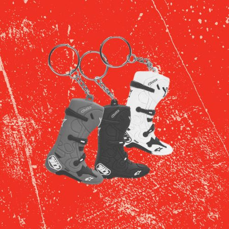 Three Alpinestars Motorcycling Riding Boots Key rings on red background