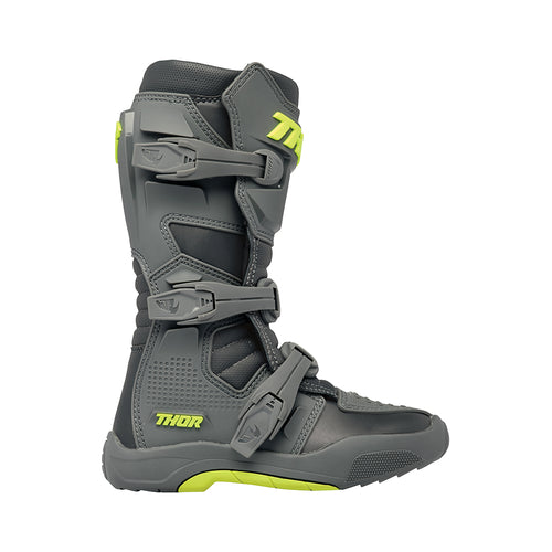 A pair of THOR MX Blitz XR youth boots in gray and charcoal, accented with neon yellow. Made from synthetic materials, they feature multiple adjustable straps and textured soles. One boot is positioned upright while the other is angled to display its back and side profile. Both boots prominently showcase the Thor logo.