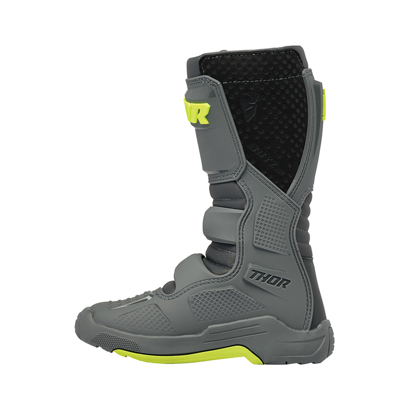 A pair of THOR MX Blitz XR youth boots in gray and charcoal, accented with neon yellow. Made from synthetic materials, they feature multiple adjustable straps and textured soles. One boot is positioned upright while the other is angled to display its back and side profile. Both boots prominently showcase the Thor logo.