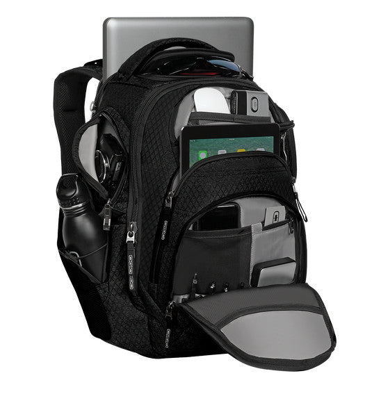 The Ogio REV Laptop Backpack in black is shown, showcasing its sleek design and multiple compartments. Featuring ergonomic shoulder straps, it is packed with various items including a laptop, tablet, water bottle, headphones, smartphone, and other electronics—all neatly organized in their respective pockets. It also includes a Tech Vault pocket for added protection.