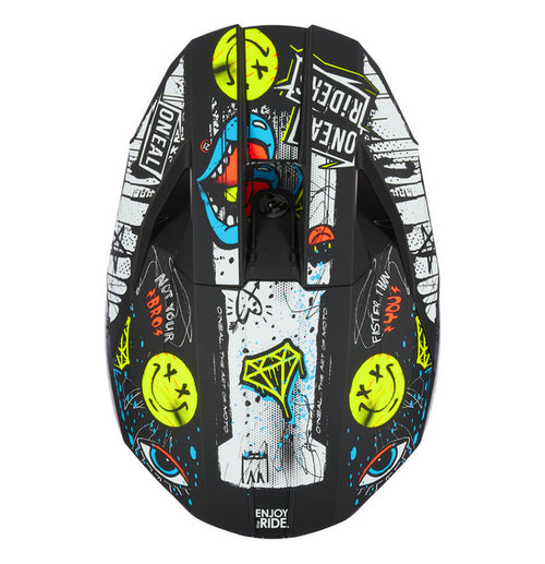 The O'Neal 2025 Youth 3SRS RANCID Helmet - Multi is a black motocross helmet adorned with vivid graffiti-style artwork. The intricate design showcases colorful letters spelling "ONEAL," various doodles, a crown, and multiple expressive faces and symbols. Featuring a Polycarbonate/ABS Shell, the helmet also includes a visor, chin guard for protection, and a washable padded liner for added comfort.