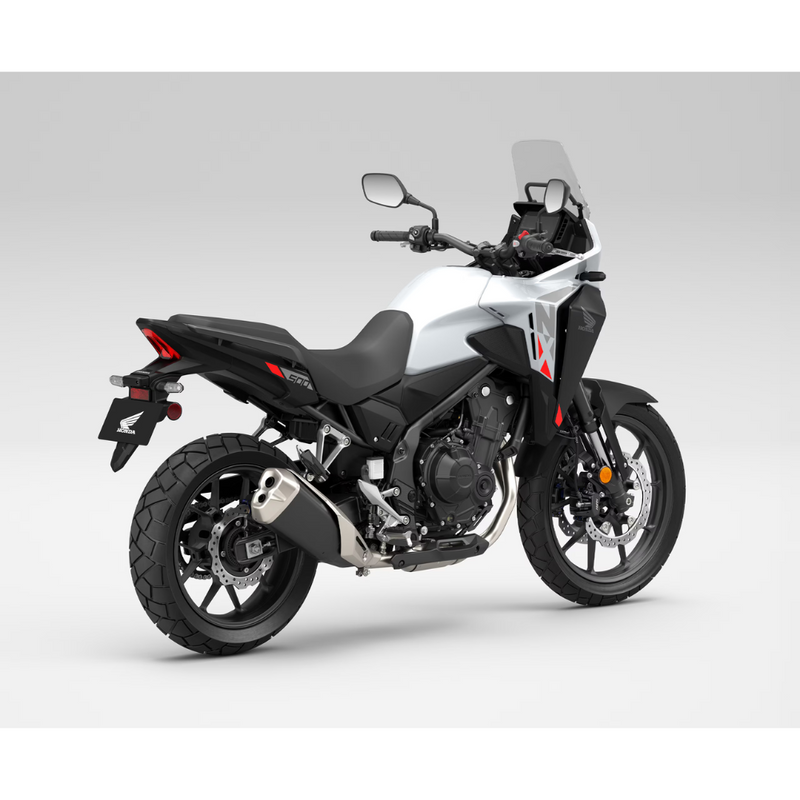 The Honda NX500, a sleek and modern motorcycle by Honda, showcases a silver and black color scheme with programmed fuel injection. It features a prominent windshield, angular design elements, and alloy wheels. The side profile accentuates its sporty and aerodynamic build.